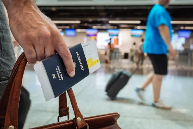 Mano con passaporto di un viaggiatore in aeroporto