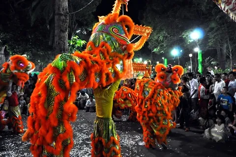 Acrobati animano un animale di cartapesta durante le feste del Tet