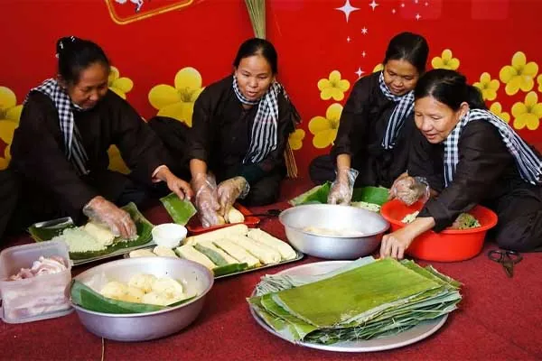 Donne vietnamite sedute in cerchio davanti ai piatti tipici del Tet