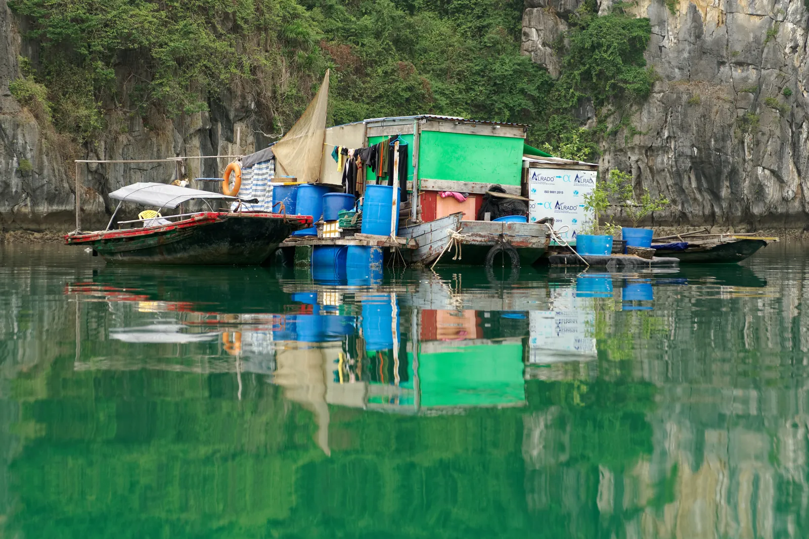 Insediamento di pescatori lungo la costa di Cat Ba con barche tradizionali e case sul mare