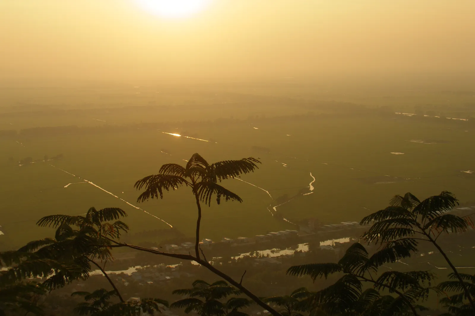 Vista dal monte Sam sui campi e i canali del Delta del Mekong al tramonto