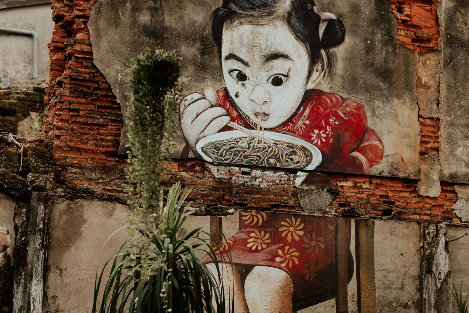 un murales che rappresenta un bambino in abito tradizionale vietnamita che mangia una zuppa