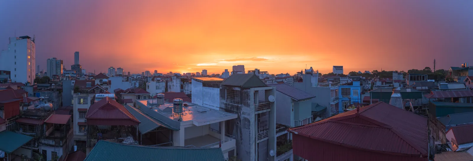 Tramonto su Hanoi dopo la pioggia Tramonto su Hanoi dopo un temporale con tetti della città all'orizzonte