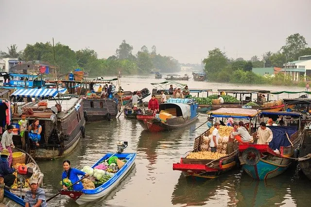 Barche con mercanzie in un mercato galleggiante nel Delta del Mekong