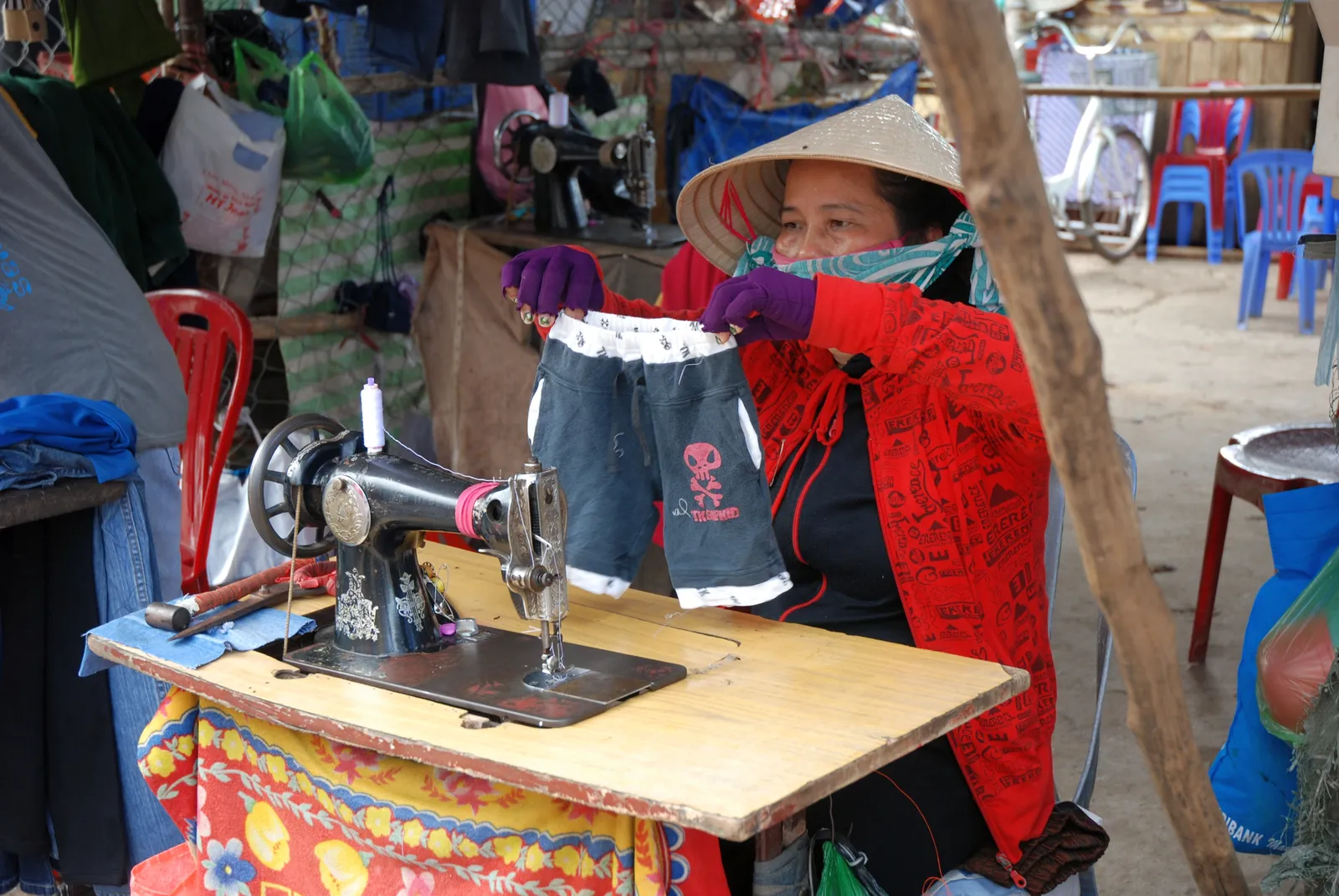 Sarta vietnamita al lavoro Sarta vietnamita al lavoro con la macchina da cucire in un mercato del Vietnam