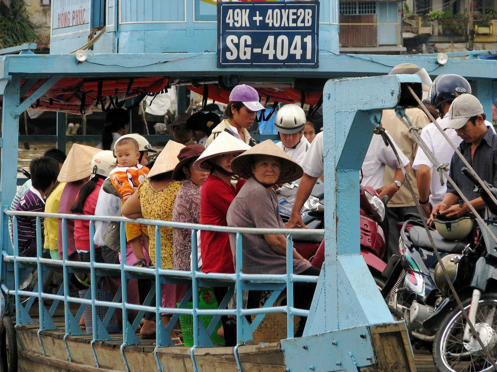 Traghetto sul delta del Mekong Persone locali con cappelli conici sul traghetto nel delta del Mekong, dove le frasi vietnamite utili fanno la differenza