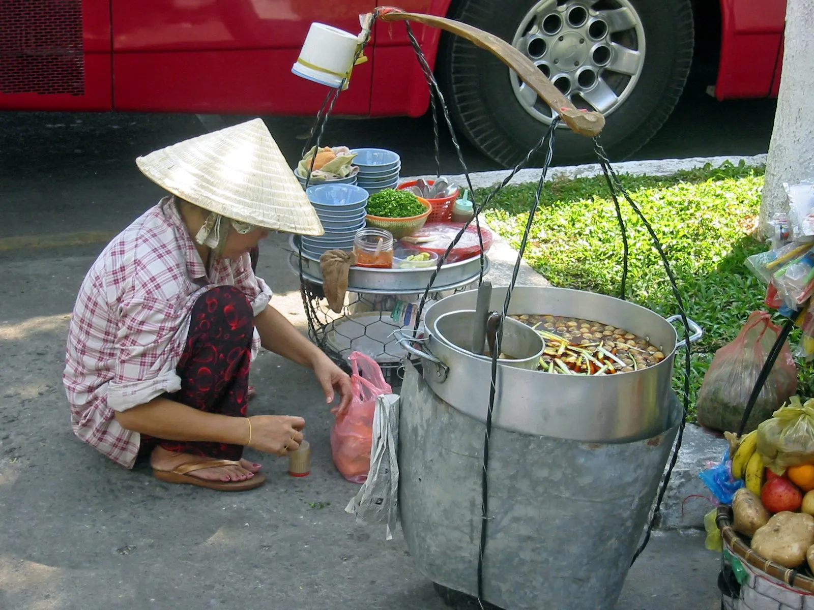 Street food vietnamita Bancarella di street food vietnamita con venditrice e cibi tipici da ordinare con le frasi vietnamite utili