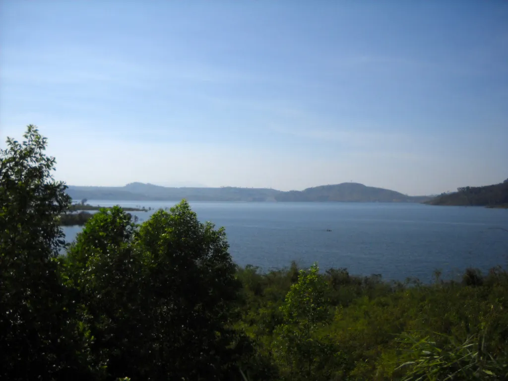 Vista panoramica del lago Lak con case galleggianti e colline verdi sullo sfondo