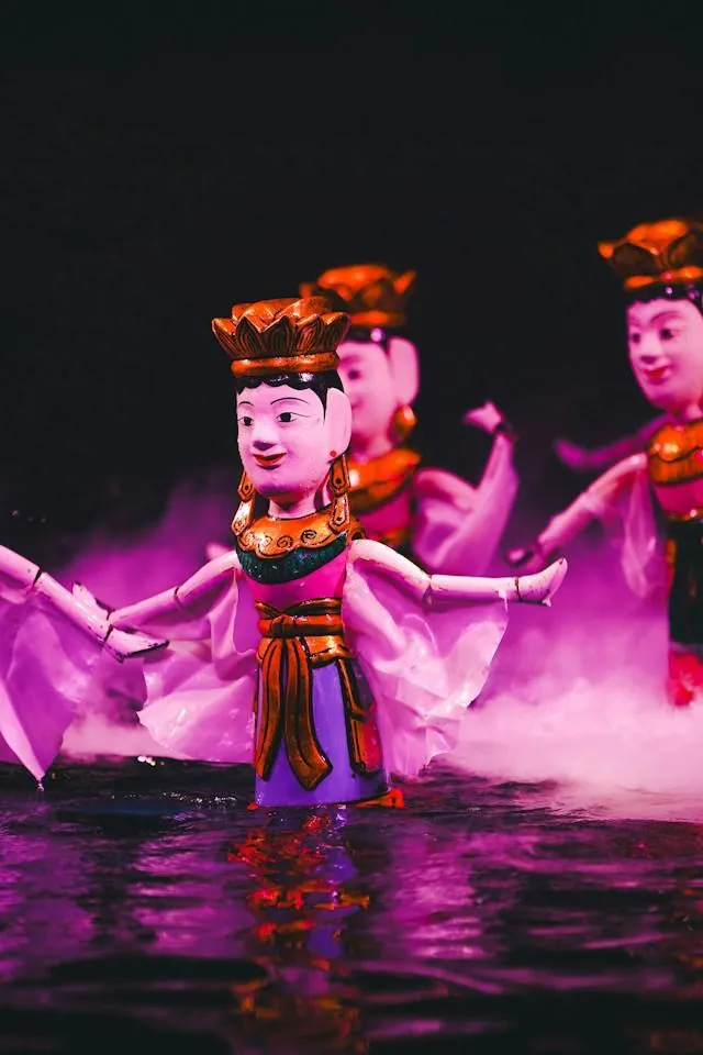 Marionette danzanti sull'acqua Marionette vietnamite laccate e dorate danzano sull'acqua durante uno spettacolo tradizionale di marionette sull'acqua