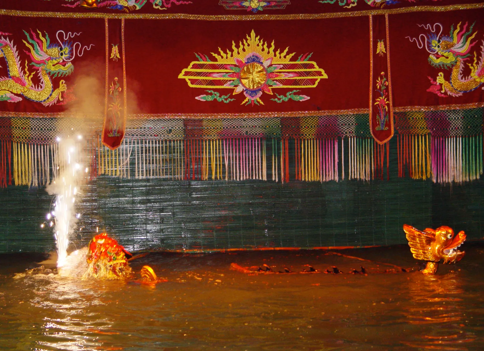 Spettacolo di marionette sull'acqua ad Hanoi Palcoscenico d'acqua del teatro Thang Long ad Hanoi durante uno spettacolo di marionette vietnamite con draghi dorati e fontane