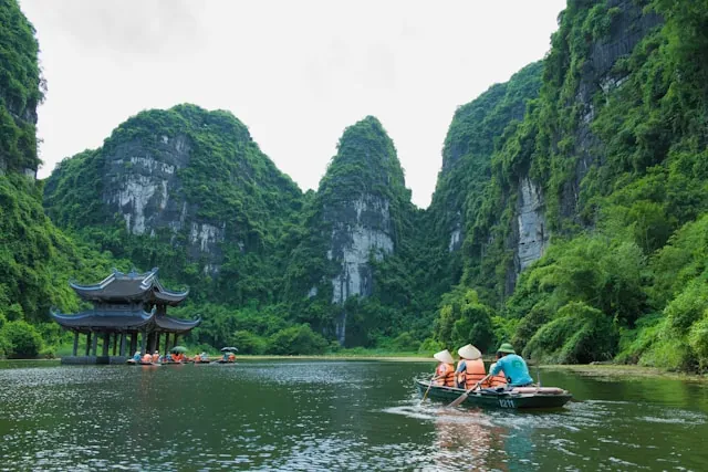Barca locale sul fiume tra il paesaggio carsico di Tam Coc, Ninh Binh