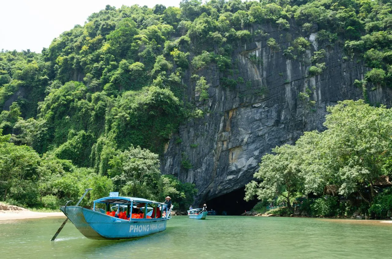 Barca verso la grotta Barca all'ingresso di una grotta fluviale nel Vietnam