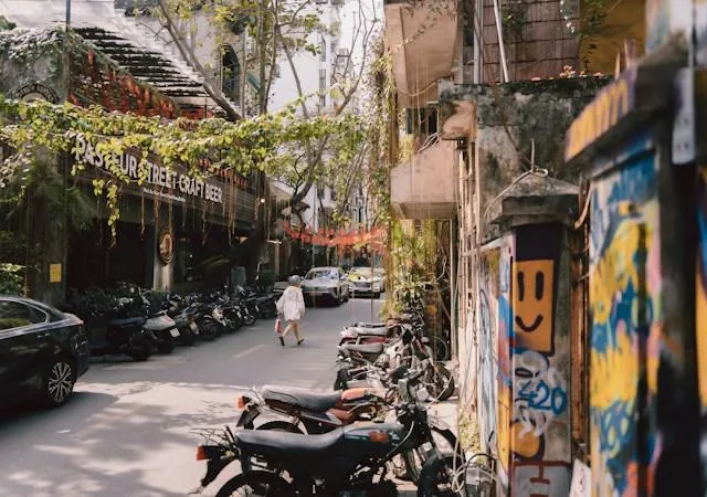 Una strada del centro di Saigon con moto parcheggiate e l'insegna del birrificio artigianale Pasteur Street Craft Beer
