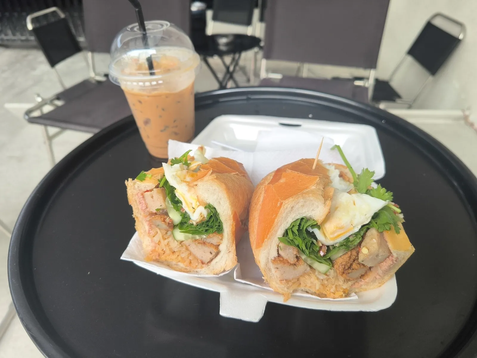 Banh mi e caffè ghiacciato a Saigon Banh mi saigonese tagliato a metà con caffè ghiacciato al latte condensato, street food di Ho Chi Minh City