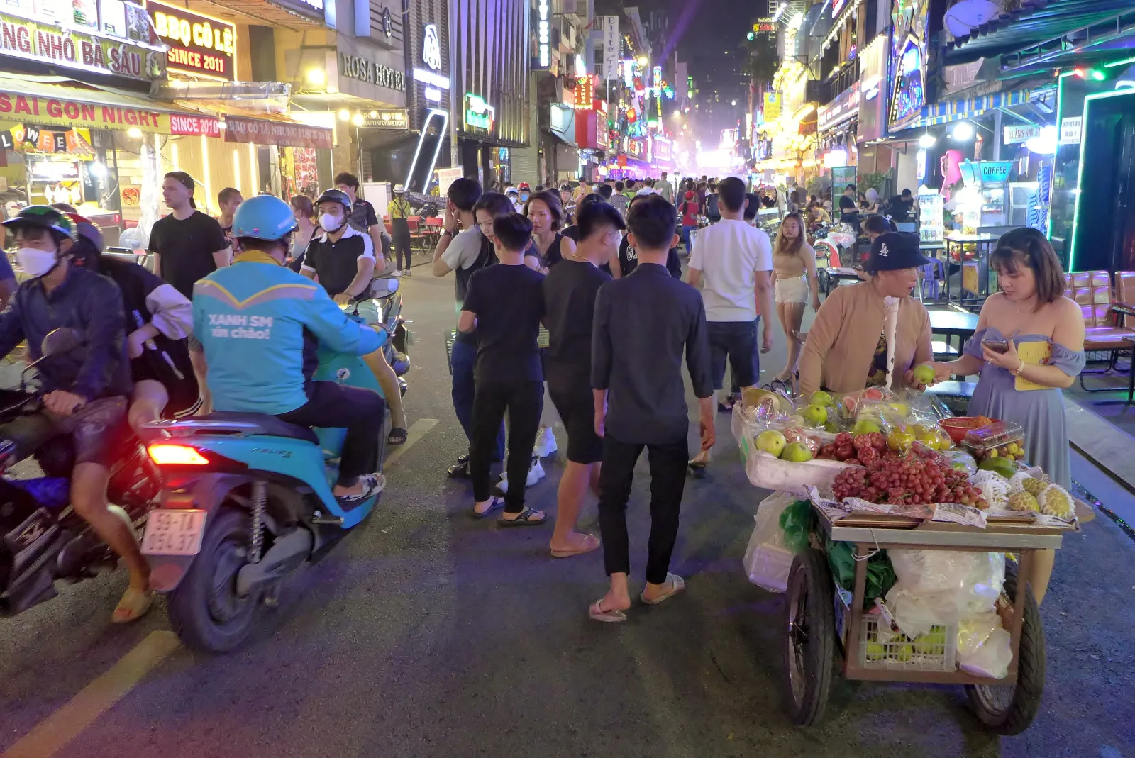 Bui Vien di notte, la via dei backpacker di Saigon Via Bui Vien a Saigon di notte, pedonale nel fine settimana, tra luci al neon, motorini e bancarelle di street food