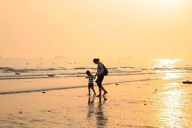 mamma e figlio in riva al mare al tramonto